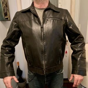 GUESS polyester/leather feel and look. Fits well.